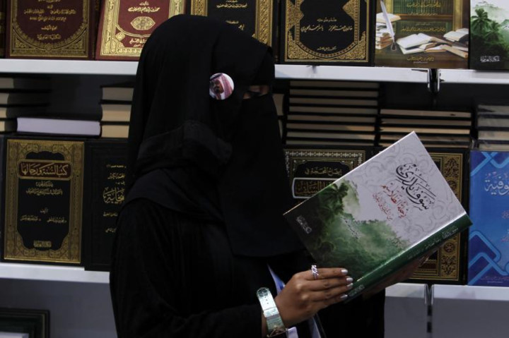 Cô gái trẻ trong bộ trang phục kín đáo của người Hồi giáo say sưa đọc một cuốn sách tại Hội chợ sách quốc tế Riyadh.