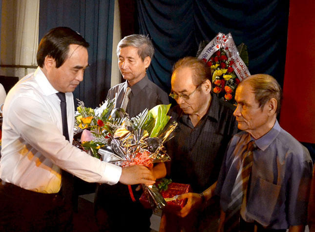 Chủ tịch UBND thành phố Văn Hữu Chiến tặng hoa chúc mừng tác giả Hồ Hải Học (giữa) nhận giải thưởng Nhà nước về Văn học-Nghệ thuật năm 2012.          Ảnh: V.N