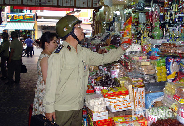 An employee from the local Market Management Bureau checking a goods stand