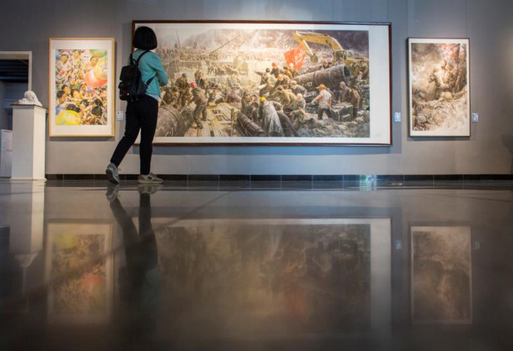 Một nữ du khách ngắm nhìn 3 bức tranh của các nghệ sĩ Triều Tiên tại Bảo tàng Nghệ thuật Mansudae.