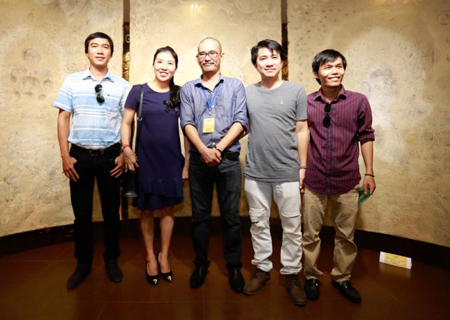 Họa sĩ Phan Hải Bằng (đứng giữa) người sáng lập dự án Nghệ thuật trúc chỉ Việt Nam mang triển lãm trúc chỉ đến Đà Nẵng không ngoài mục đích chia sẻ niềm đam mê trong sáng tạo nghệ thuật.