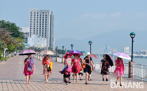 Foreign visitors walking along Bach Dang Street riverside promenade