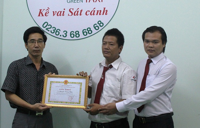 Phó Giám đốc Sở Du lịch thành phố Đà Nẵng Trần Chí Cường (ngoài cùng bên trái) trao giấy khen cho tài xế Nguyễn Trung Hiếu (đứng giữa) vì đã trung thực trả l