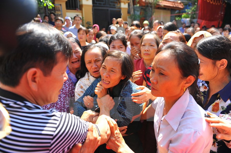 Hình ảnh xúc động của mẹ phóng viên Đinh Hữu Dư và người thân trong giờ phút tiễn đưa con. (Ảnh: Ninh Đức /TTXVN​)