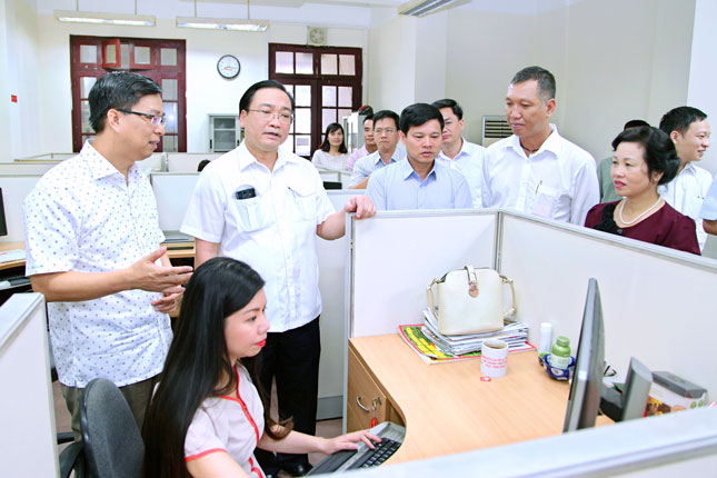 Bí thư Thành ủy Hà Nội Hoàng Trung Hải (thứ hai, từ trái) thăm quy trình làm báo tại tòa soạn Báo Hànộimới.