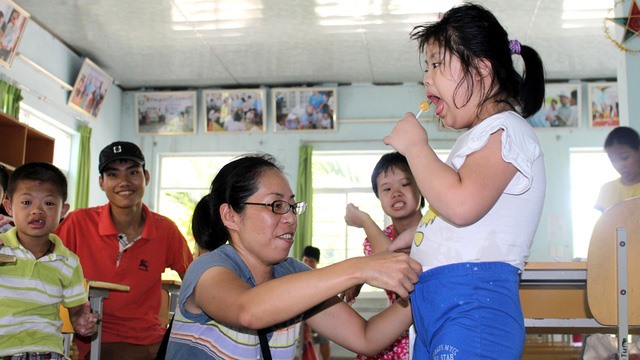 Yo tends to a girl with disabilities. - Photos tuoitre.vn Read more at http://vietnamnews.vn/society/416462/japanese-volunteer-changes-lives-of-agent-orange-kids.html#iu00iXWIfeDvAECr.99