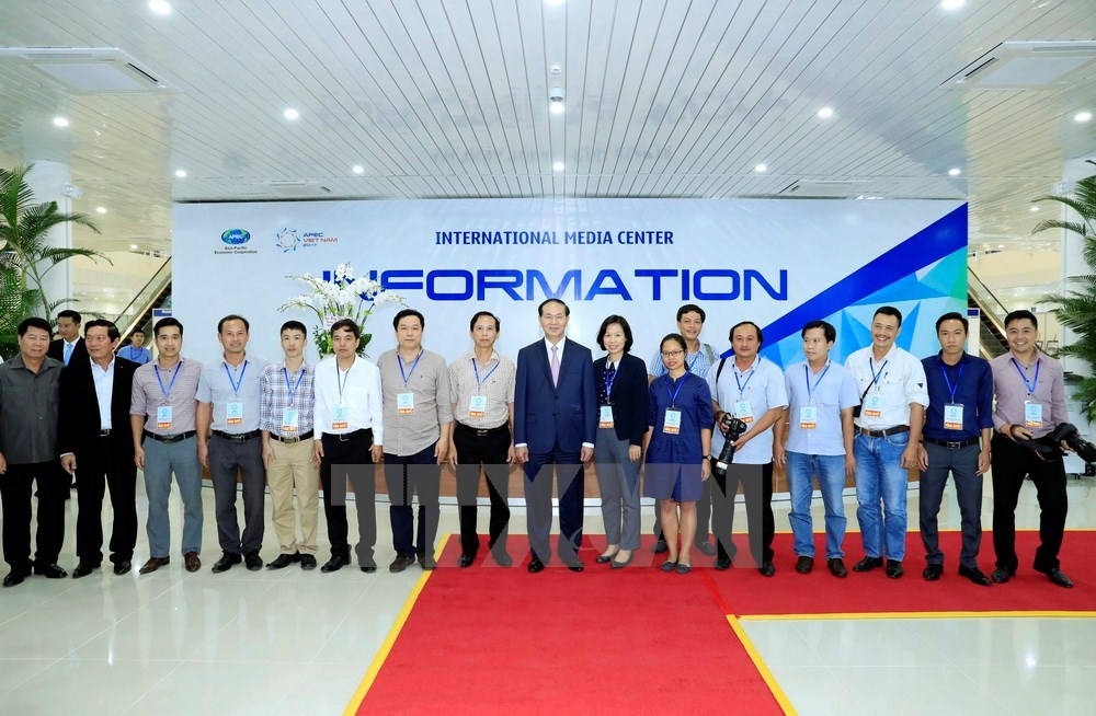 President Tran Dai Quang and Vietnam News Agency reporters pose for a photo (Photo: VNA)