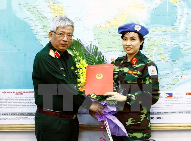 Deputy Minister of National Defence Senior Lieutenant General Nguyen Chi Vinh (L) hands over to Major Do Thi Hang Nga a decision sending her to UN peacekeeping mission in South Sudan (Photo: VNA)