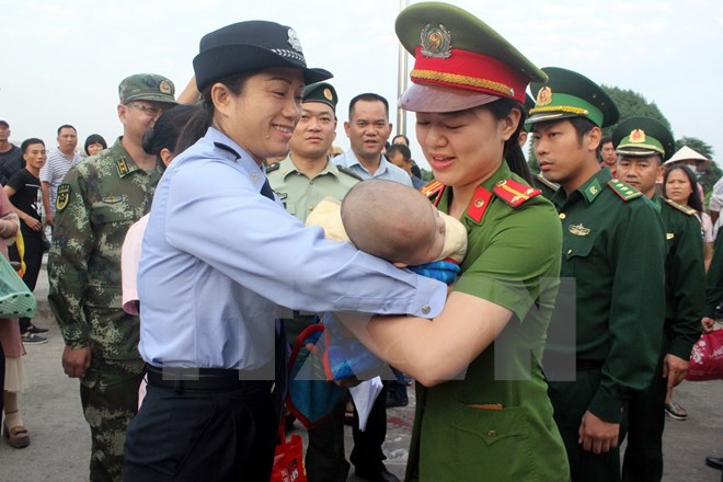 Công an thành phố Móng Cái (Quảng Ninh) phối hợp với Đồn Biên phòng Cửa khẩu Quốc tế Móng Cái tiếp nhận một trẻ em bị bán sang Trung Quốc. (Ảnh: Nguyễn Hoàng/TTXVN)