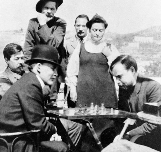 Lenin (bìa phải) chơi cờ với nhà khoa học-nhà cách mạng Alexander Bogdanov khi thăm nhà văn Maxim Gorky (đứng, đội mũ) vào năm 1908. Cờ vua là sở thích của Lenin. Ảnh: RIA.