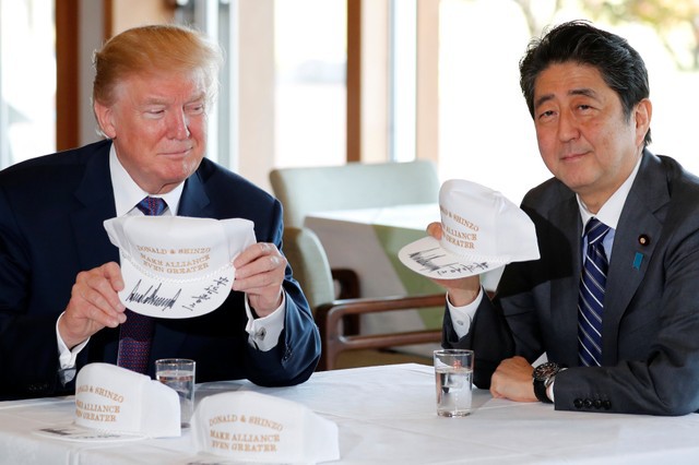 Tổng thống Trump và Thủ tướng Abe chụp ảnh cùng hai chiếc mũ lưỡi trai có chữ ký của họ.