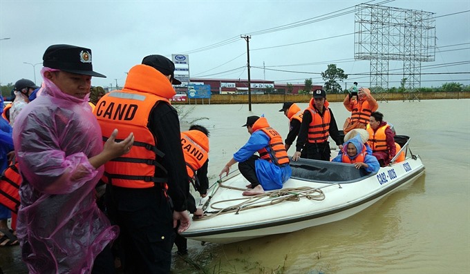 Police in Quảng Nam Province help evacuate people from flooded areas. — VNA/VNS Photo Nguyễn Sơn Read more at http://vietnamnews.vn/society/416915/typhoon-damrey-leaves-29-dead-29-missing.html#7sqVMl01j5hczg74.99