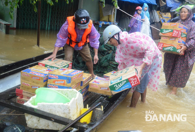Nhu yếu phẩm được mang lên thuyền để đưa vào các khu vực ngập lũ sâu ở xã Hòa Nhơn