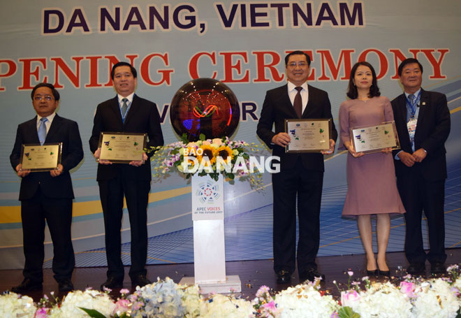 A representative from VOF 2017’s organisers (1st right), presenting souvenir medals to Professor Tran Van Nam (1st left), the Director of the University of Da Nang (UDN), Secretary Hai (2nd left), Chairman Tho (3rd right) and a representative from the UDN (2nd right)