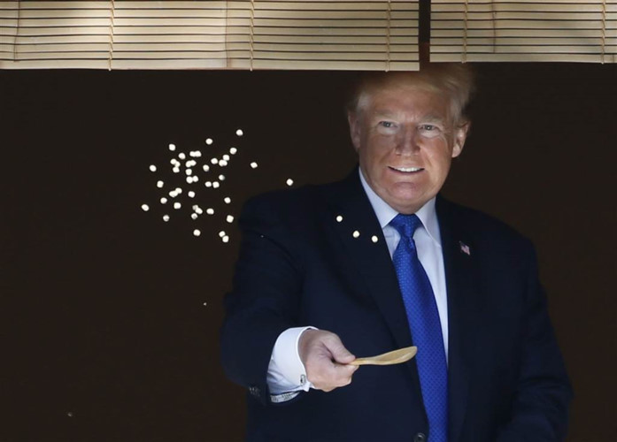 Ông Trump thích thú cho cá chép ăn trước khi ông dùng bữa trưa với Thủ tướng Nhật ở cung điện Akasaka vào hôm 6/11. Ảnh: AP.