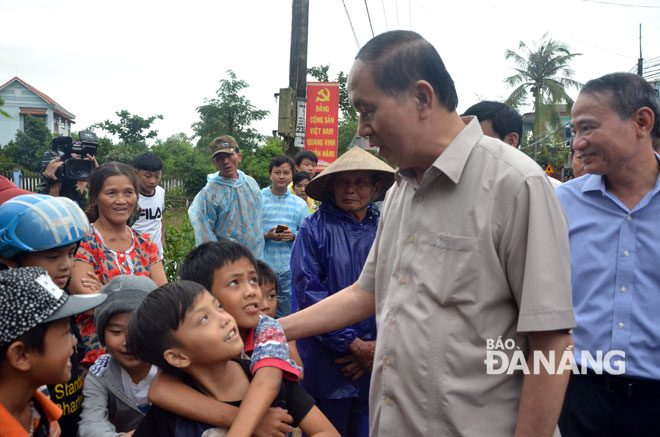 Chủ tịch nước Trần Đại Quang ân cần thăm hỏi trẻ em khu vực bị  ngập lụt. 