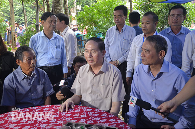 Chủ tịch nước Trần Đại Quang (giữa) và Bí thư thành ủy Trương Quang Nghĩa (phải) thăm hỏi, động viên người dân nhanh chóng khắc phục thiệt hại do lũ lụt gây ra.                                    								                 Ảnh: Việt Dũng 
