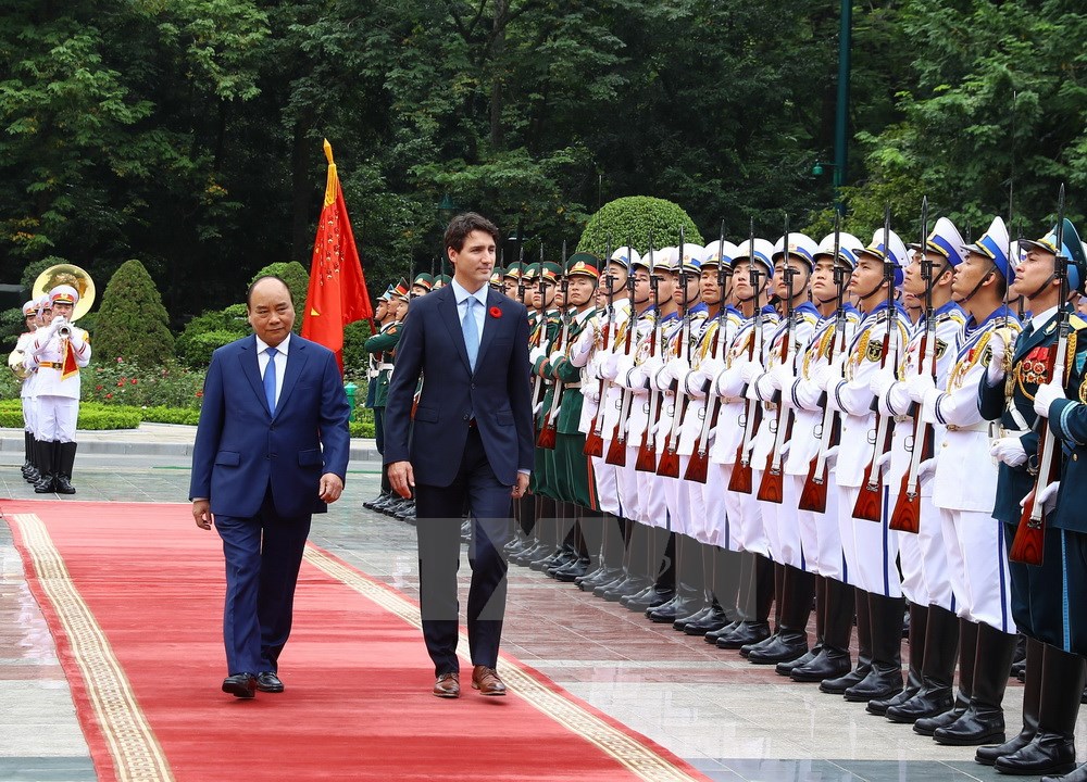 Thủ tướng Nguyễn Xuân Phúc và Thủ tướng Canada Justin Trudeau duyệt Đội danh dự Quân đội nhân dân Việt Nam. (Ảnh: Thống Nhất/TTXVN)