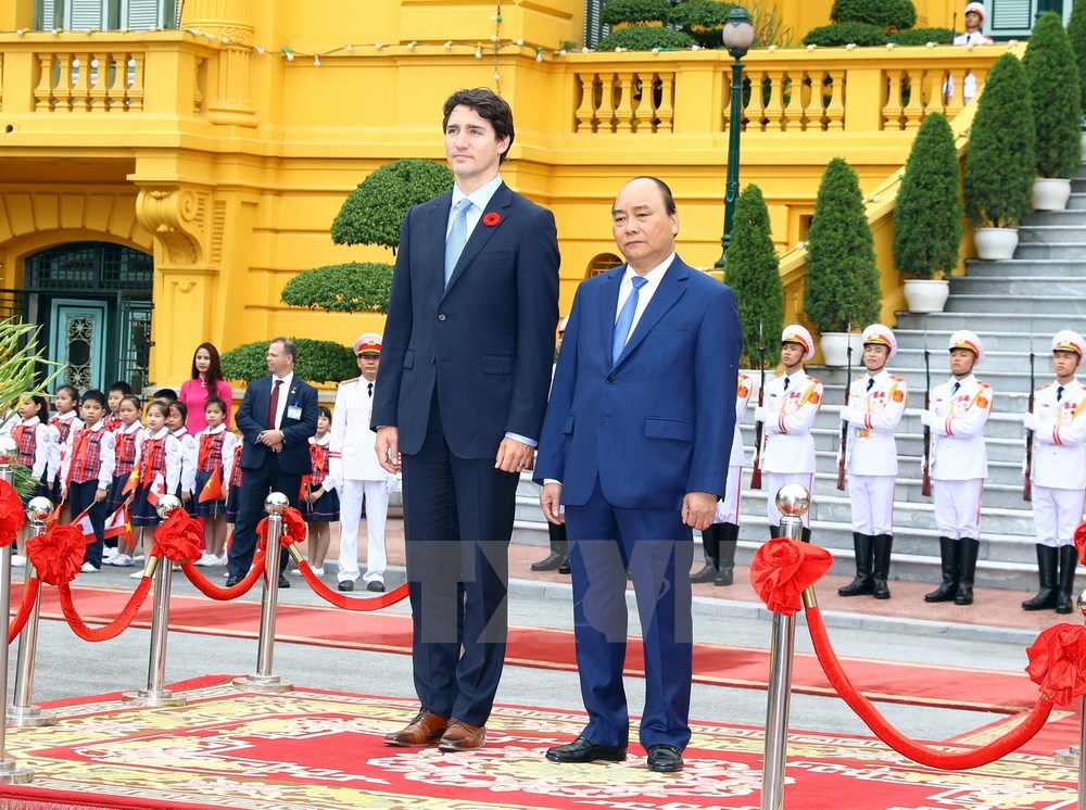 Thủ tướng Nguyễn Xuân Phúc và Thủ tướng Canada Justin Trudeau trên bục danh dự nghe Quân nhạc cử Quốc thiều hai nước. (Ảnh: Thống Nhất/TTXVN)