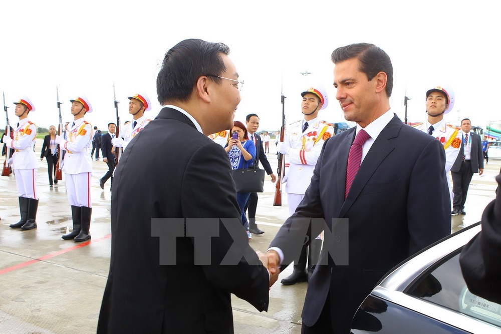  Mexican President Enrique Peña Nieto (right) is welcomed by Vietnamese Minister of Science and Technology Chu Ngoc Anh (Photo: VNA)