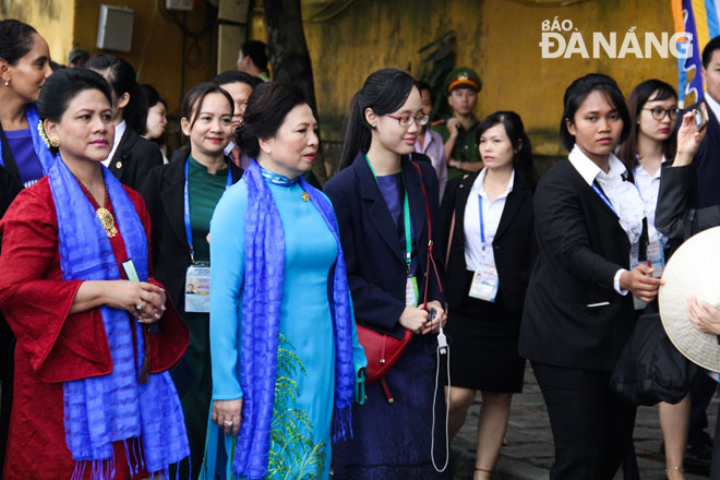 Ms Nguyen Thi Hien (in blue ‘ao dai’) and the spouses of the APEC leaders visiting the site and…