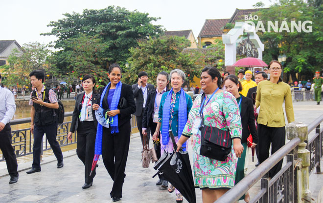    The visitors strolling across the An Hoi Bridge