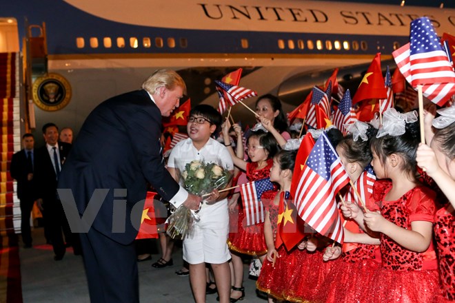 Tổng thống Trump đã dành bó hoa mình được tặng cho những bé thiếu nhi chào đón ông đến với Thủ đô Hà Nội. (Ảnh: Minh Sơn/Vietnam+)