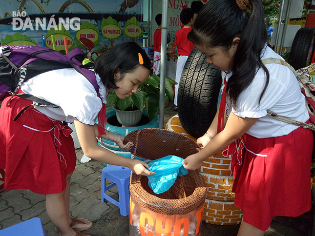 Tại Ngày hội môi trường, học sinh sử dụng thùng rác làm bằng vật liệu tái chế từ chai nhựa.