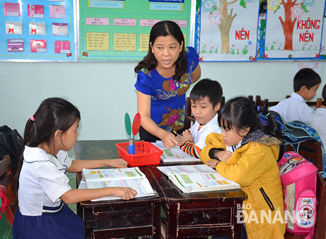 Cô Lê Thị Chanh đang hướng dẫn các học sinh Trường tiểu học Hòa Phú làm bài tập. Ảnh: Đ.L