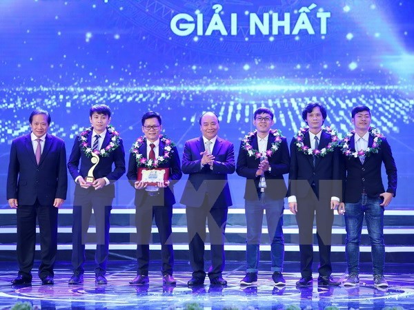Prime Minister Nguyen Xuan Phuc (centre) and Minister of Information and Communications Truong Minh Tuan (first, left) present the first award in the field of IT (Photo: VNA)