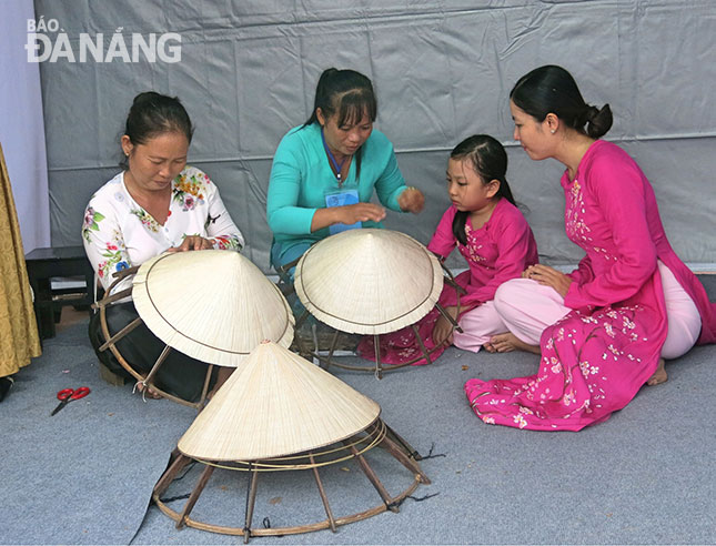 Trình diễn làm nón lá được người dân quan tâm và trải nghiệm tại liên hoan các làng nghề truyền thống 2017.