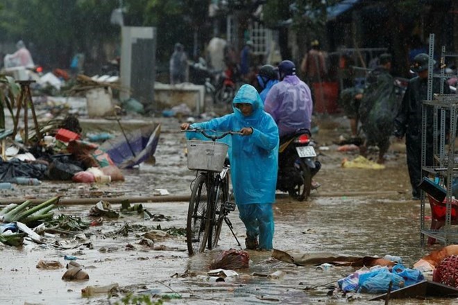 A woman walks along a street full of debris caused by Typhoon Damrey in the ancient UNESCO heritage city  of Hoi An, Vietnam (Photo Reuters/VNA