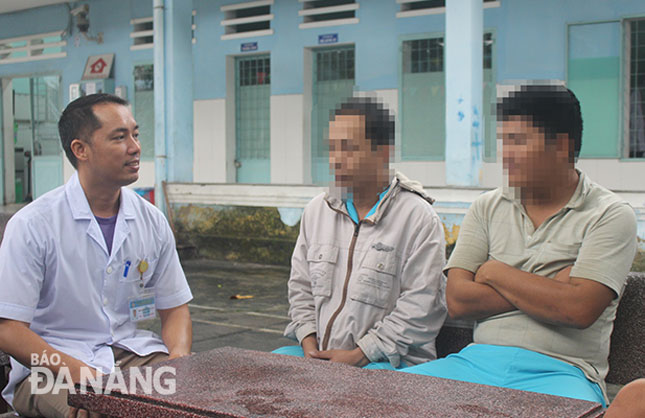 Anh Nguyễn Văn Lâm (trái) thường xuyên dành thời gian trò chuyện với người bệnh tại khuôn viên Bệnh viện Tâm thần Đà Nẵng. Ảnh: T.Y