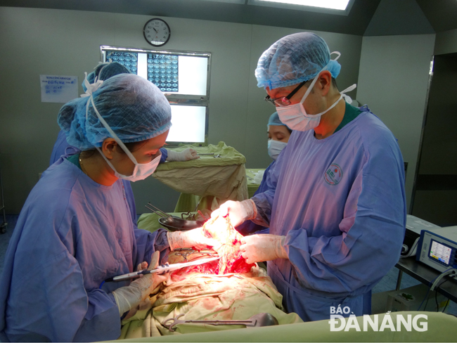 Bác sĩ Đinh Anh Trí (phải) hướng dẫn một ca mổ ung thư buồng trứng tại Bệnh viện Ung bướu Đà Nẵng. Ảnh: PHAN CHUNG