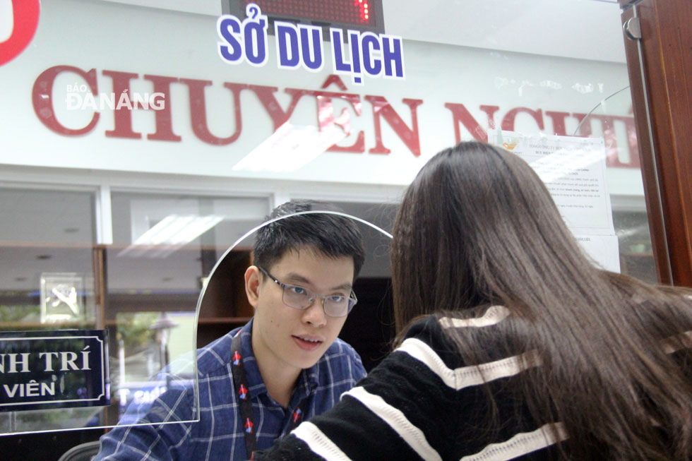 A male employee from the municipal Tourism Department answering questions raised by a female citizen during the completion of her administrative dossiers