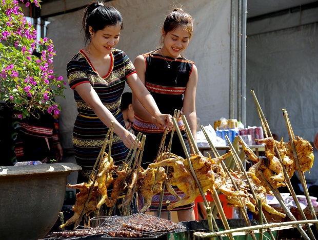  Ba Na ethic minority girls grilling chicken served to visitors during the festival