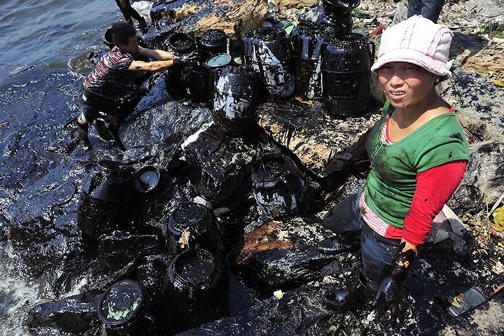   Ngư dân tự khắc phục dầu tràn ra ở gần cảng Đại Liên, tỉnh Liêu Ninh.