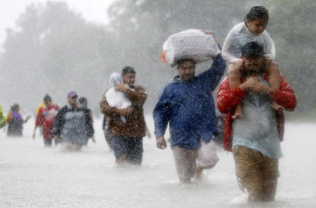 Những người dân đội mưa đi sơ tán khi siêu bão Harvey lịch sử đổ bộ vào thành phố Houston, bang Texas, Mỹ hồi tháng 8.