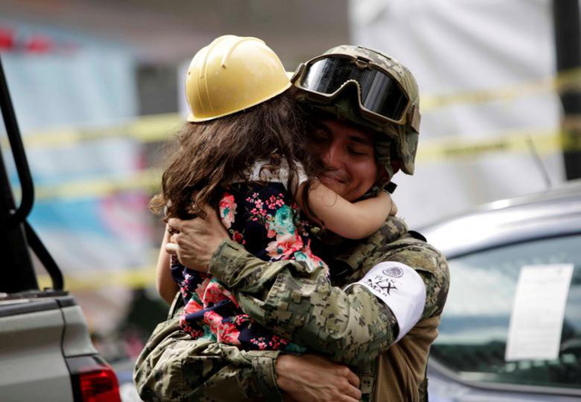 Lính thủy quân lục chiến Mexico mỉm cười khi ôm bé gái thoát khỏi đống đổ nát của một ngôi nhà bị sập do động đất hồi tháng 9.