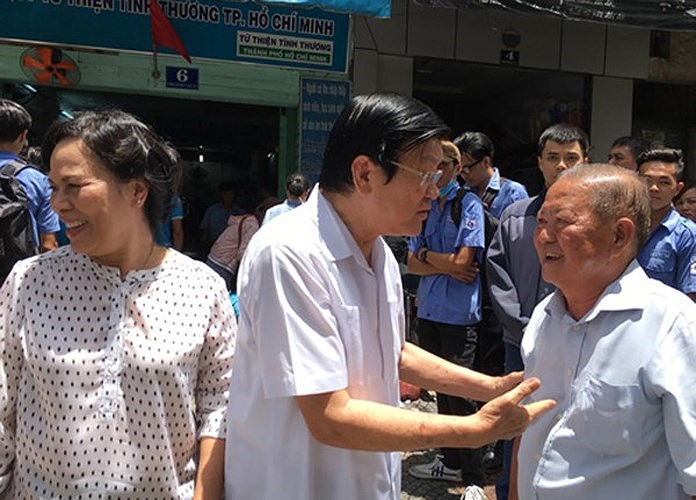 Nguyên Chủ tịch nước nói chuyện với nhà báo Nam Đồng, nguyên Tổng Biên tập báo Pháp luật TPHCM, người sáng lập hệ thống quán cơm xã hội Nụ Cười. (Ảnh: Pháp luật TPHCM)