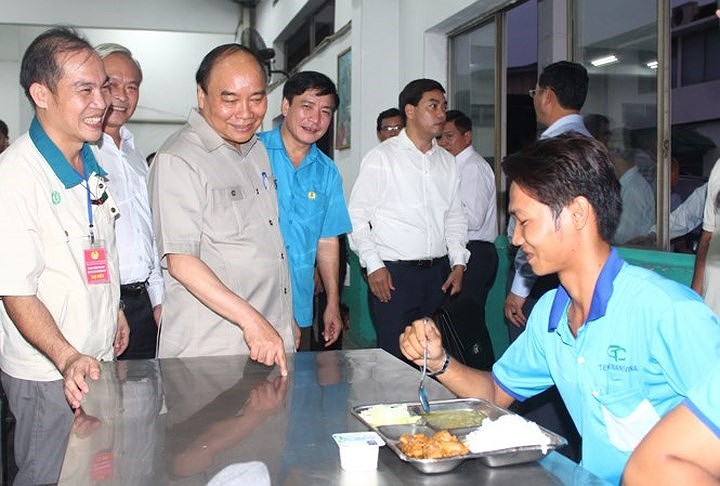 Sau khi ăn xong, Thủ tướng Nguyễn Xuân Phúc đi đến nhiều bàn ăn, ân cần thăm hỏi về khẩu phần ăn của công nhân hàng ngày trước khi ra về. (Ảnh: Tiền Phong).