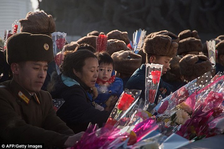 Mang theo hoa, hàng nghìn người dân Triều Tiên hôm nay tập trung về tượng đài và những nơi công cộng có chân dung các nhà lãnh đạo để kỷ niệm 6 năm ngày mất cố lãnh đạo Kim Jong-il. Ảnh: AFP/Getty.