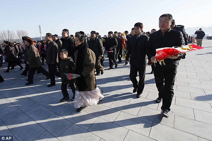 Bất chấp thời tiết lạnh giá, ngay từ sáng sớm, người Triều Tiên đã tới đặt hoa trước tượng đài ông Kim Jong Il và ông Kim Il-sung trên Đồi Mansudae. Ảnh: AP.