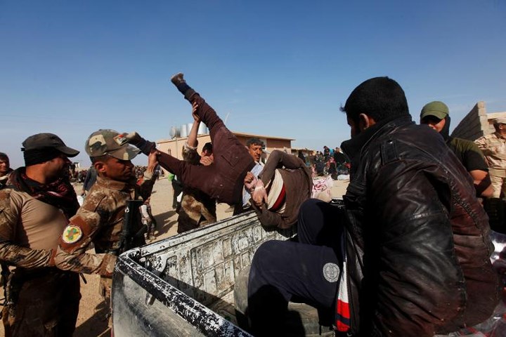   Đặc nhiệm Iraq bắt giữ một kẻ nghi là IS và quăng người này lên xe, ở tây Mosul vào ngày 26-2.