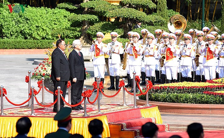 Tổng Bí thư Nguyễn Phú Trọng mời Tổng Bí thư, Chủ tịch nước Bounnhang Vorachith bước lên bục danh dự, quân nhạc cử quốc thiều hai nước.