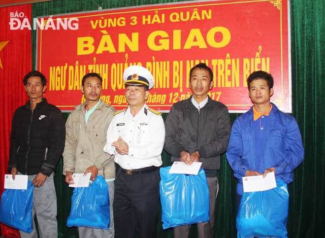Phó Chính ủy Vùng 3 Hải quân tặng quà và lộ phí cho các ngư dân về quê đoàn tụ gia đình.