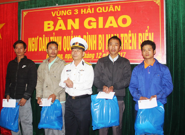 Phó Chính ủy Vùng 3 Hải quân tặng quà và lộ phí cho các ngư dân tàu cá QB 98436 TS về quê đoàn tụ gia đình.