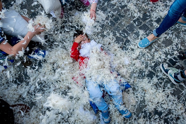   Một đứa trẻ thích thú tham dự lễ hội Đánh nhau bằng gối bông Pillow Fight tại Romania. Ảnh: AFP