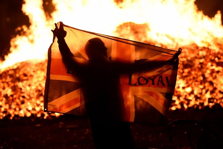 Một người đàn ông cầm lá cờ Anh tham dự lễ hội mừng ngày 12/7 tại Bắc Ireland. Ảnh: Reuters