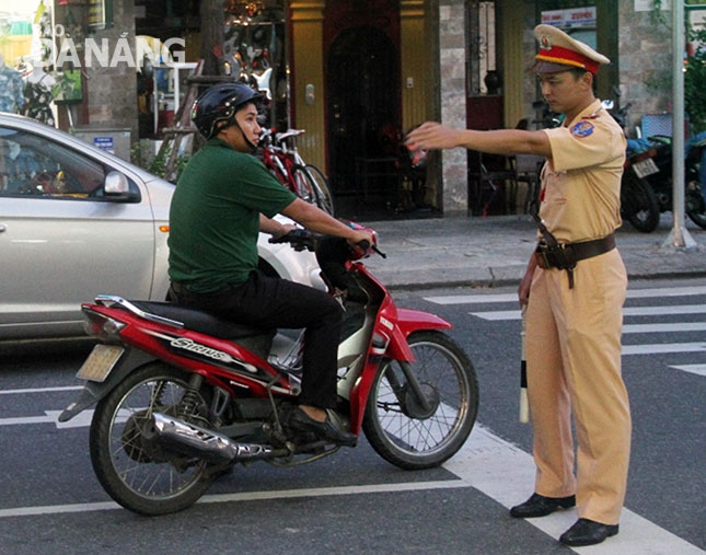 Cảnh sát giao thông hướng dẫn người tham gia giao thông đi đúng phần đường, làn đường.Ảnh: NGỌC PHÚ